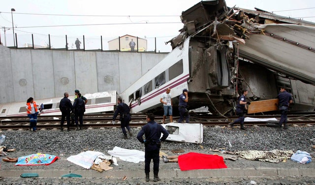 Emergency personnel respond to the scene of a train derailment in Santiago de Compostela, Spain, on Wednesday, July 24, 2013. A train derailed in northwestern Spain on Wednesday night, toppling passenger cars on their sides and leaving at least one torn o 