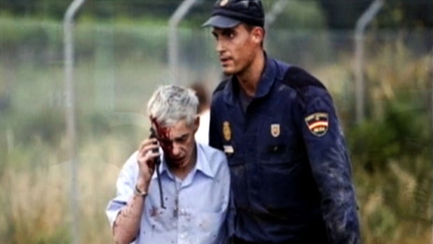 Francisco Jose Garzon Amo, driver of a train that crashed on the outskirts of Santiago de Compostela, Spain, July 24, 2013, is led away from the scene of the accident. 