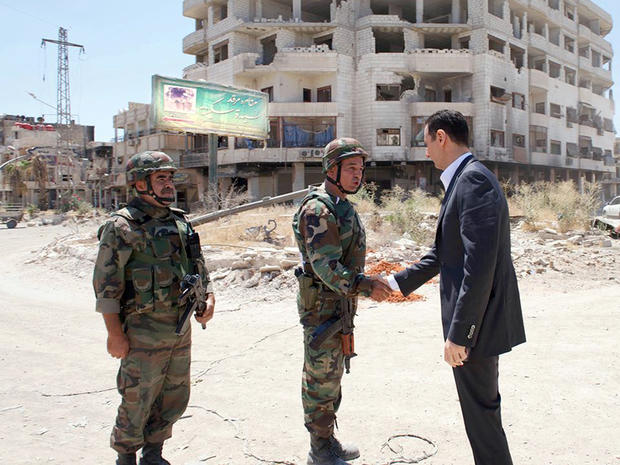 Syrian President Bashar Assad purportedly shakes hands with a solider during Syrian Arab Army day in Darya, Syria, in this image posted on the official Facebook page of the Syrian Presidency Aug. 1, 2013. 