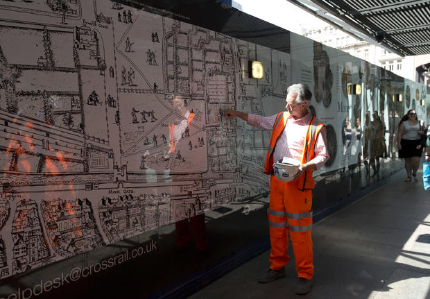 A member of the the archaeological team from the Museum of London points to the present day position of London's Liverpool Street Station on a 16th century map of the city 