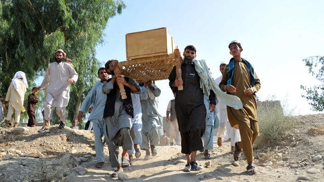 Afghan men carry a coffin towards a funeral ceremony after an explosion in the Ghani Khel district of Nangarhar province 