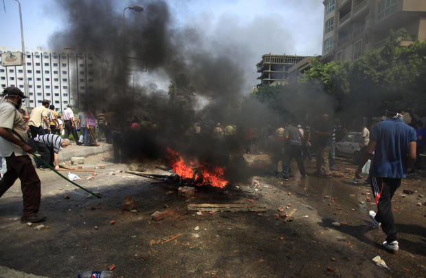 Supporters of Egypt's ousted President Mohammed Morsi clash with the Egyptian security forces as they the forces move in to clear their sit-in camp 