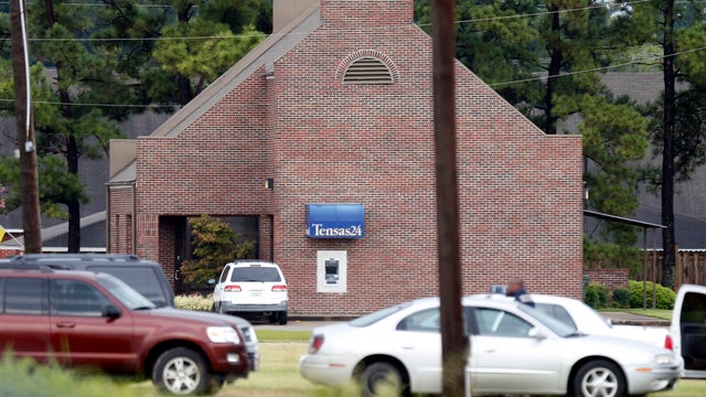 Line of automobiles belonging to a number of law enforcement agencies flank Tensas State Bank branch in St. Joseph, La., during a hostage situation Tuesday, Aug. 13, 2013. A man whose family owns a store across the street from the bank took three bank emp 