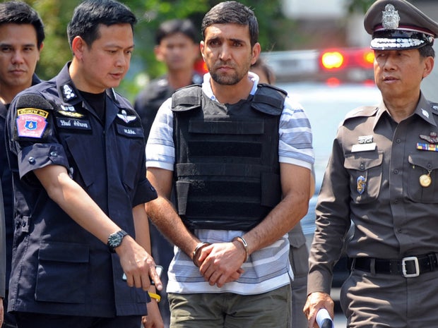 Thai police escort Iranian bomb suspect Mohammad Kharzei during an investigation at his rented house in Bangkok 