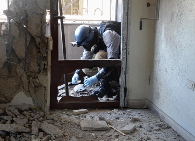 A United Nations arms expert collects samples at the site of an alleged chemical weapons attack in Damascus' eastern Ghouta suburbs 