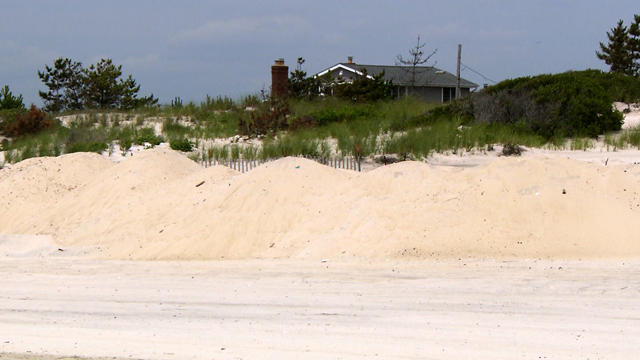 While some coastal towns say dunes offered protection, others say they wouldn't have stopped the Superstorm Sandy's massive surge. 