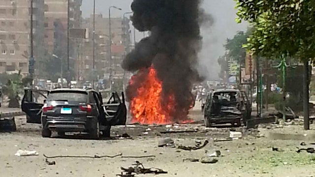 Black smoke billows from a burning car moments after a bomb attack targeted the convoy of Egypt's Interior Minister Mohammed Ibrahim 