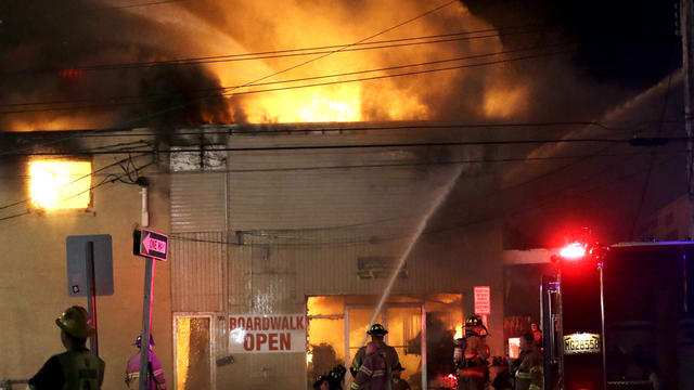 Firefighters battle a blaze in a building on the Seaside Park boardwalk on Thursday, Sept. 12, 2013, in Seaside Park, N.J. The fire began in a frozen custard stand on the Seaside Park section of the boardwalk and quickly spread north into neighboring Seas 