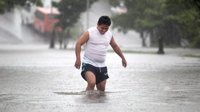 A man walks through a flooded street during heavy rains caused by Tropical Storm Ingrid in the Gulf port city of Veracruz, Mexico, Friday Sept. 13., 2013.  