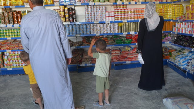 Syrian refugees shop for food at a shop in the Zaatari camp in Jordan  