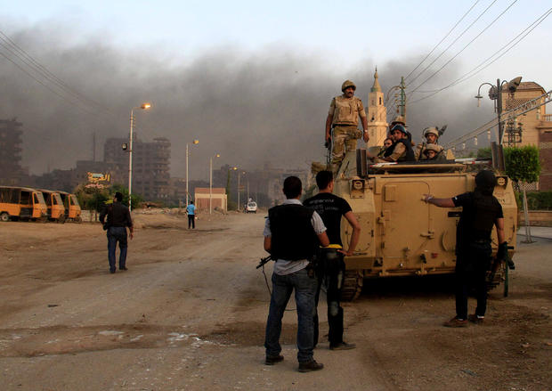Egyptian security forces take cover during clashes with suspected militants, not pictured, in the town of Kerdasa 