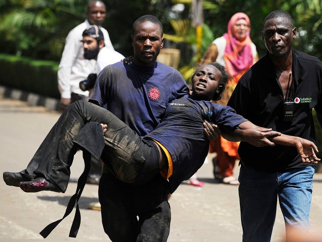 A Kenyan woman is helped to safety after masked gunmen stormed an upmarket mall and sprayed gunfire on shoppers and staff Sept. 21, 2013, in Nairobi, Kenya. 