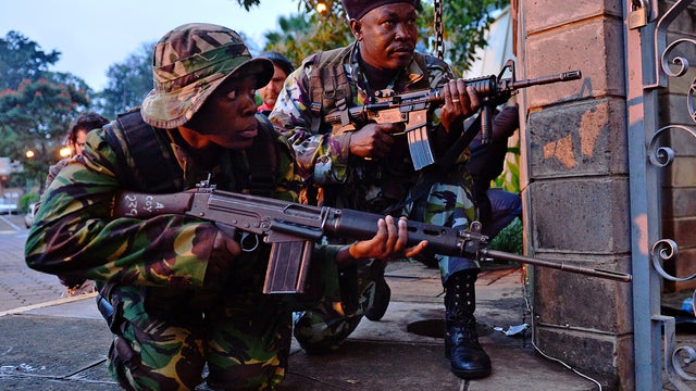 Kenyan soldiers take cover after heavy gunfire near Westgate Mall in Nairobi, Kenya, Sept. 23, 2013. 