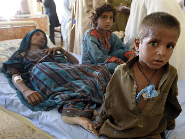 An injured Pakistani woman is surrounded by her children at a makeshift hospital in the earthquake-devastated Awaran, Pakistan, Sept. 25, 2013. 