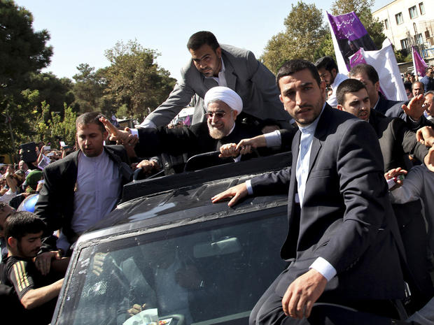 Iranian President Hasan Rouhani, center, waves to supporters upon his arrival from the U.S. near the Mehrabad airport in Tehran, Iran, Sept. 28, 2013. 