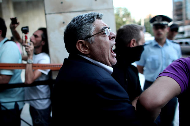 The leader of ultra-right wing Golden Dawn party Nikos Michaloliakos is escorted by masked police officers 