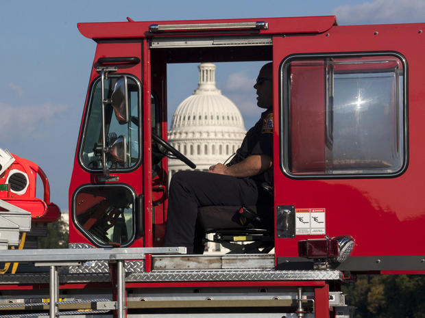 A firefighter sits in a firetruck near the scene on the National Mall in Washington where a man set himself on fire Oct. 4, 2013. 