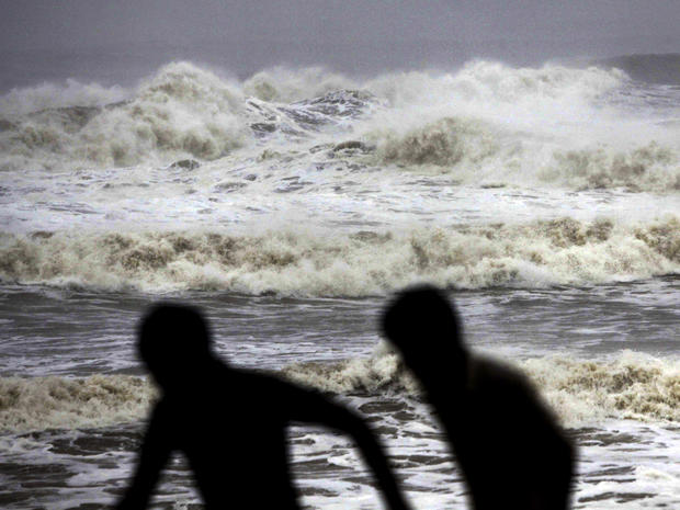 Indian people run for shelter following a cyclone warning at the Bay of Bengal coast in Gopalpur beach in Ganjam district, India, Oct. 12, 2013. 
