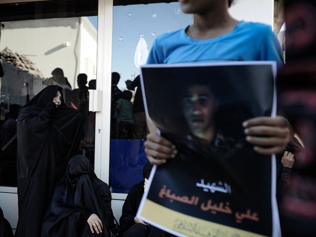 A Bahraini boy holds a poster depicting Ali Khalil Sabbagh during his funeral of Ali Khalil Sabbagh