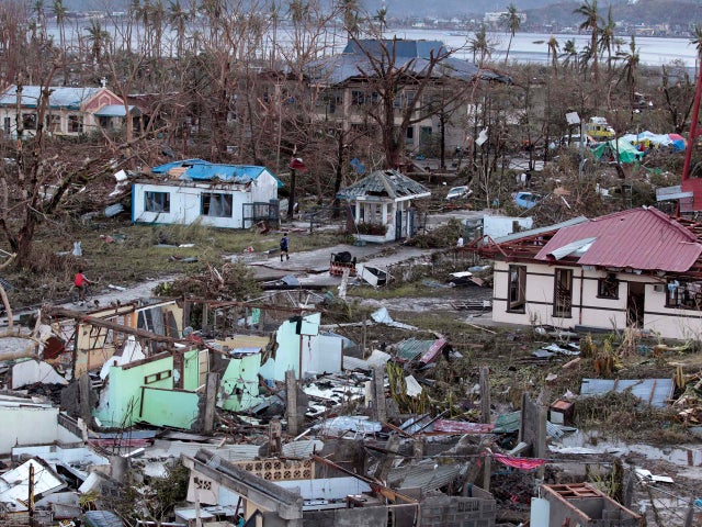 A resident walks by remains of houses after powerful Typhoon Haiyan slammed into Tacloban on hardest-hit Leyte Island in the Philippines Nov. 9, 2013. 