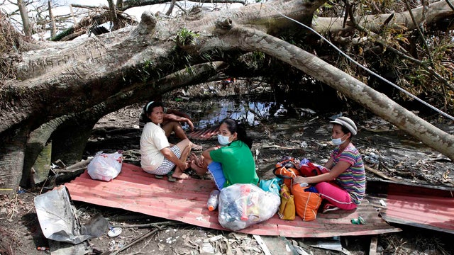 Typhoon survivors camp out at Tacloban city airport hoping to be able to board U.S. and Philippine military transport planes 