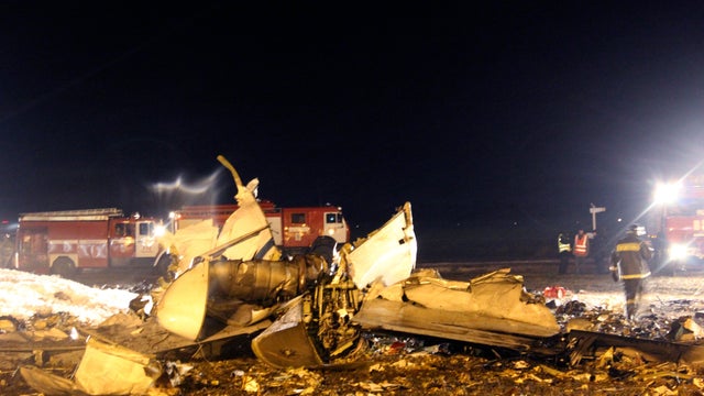 Fire fighters and rescuers work at the crash site of a Russian passenger airliner near Kazan 