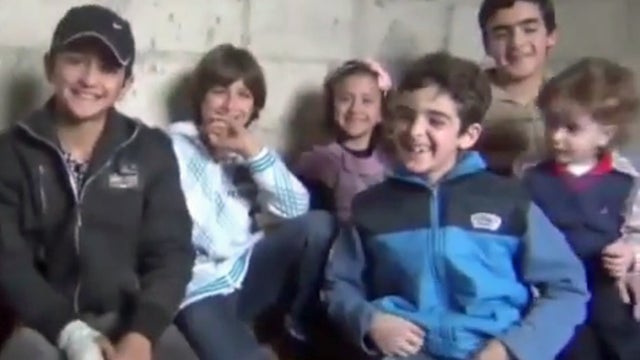 A group of Syrian children speak to an opposition activist in the eastern Damascus suburb of Jobar  