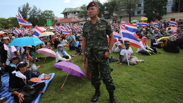 A Thai soldier stands as anti-government protesters sit at the Royal Thai Army compound in Bangkok 