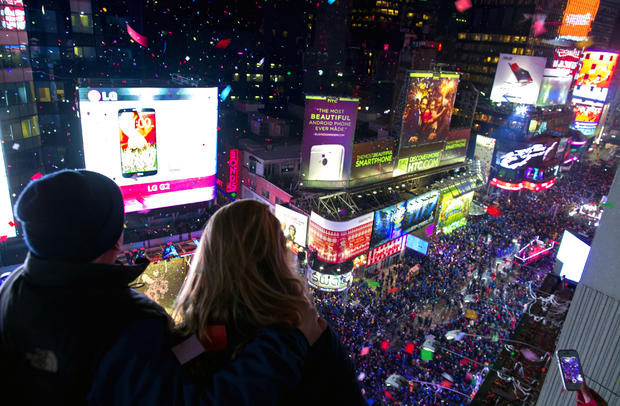 Kenn Magowan, left, Anna Edgerly-Moore, both of New York, look out over Times Square, Jan. 1, 2014 as the new year is celebrated 