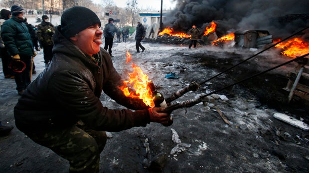 Protesters use a large slingshot to hurl a Molotov cocktail at police in central Kiev, Ukraine, Jan. 23, 2014. 