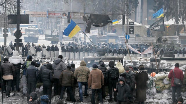 Protesters guard barricades in front of riot police in Kiev 