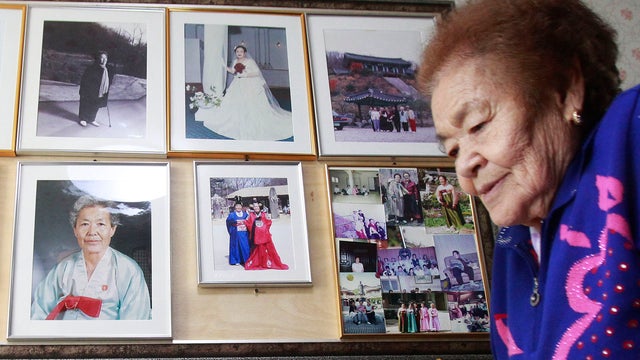 Kim Gun-ja, former comfort woman who was forced to serve for the Japanese troops as a sex slave during World War II, passes by her wedding picture 