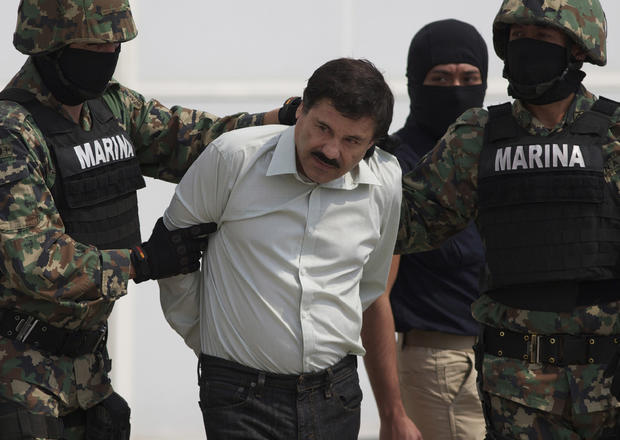 Joaquin "El Chapo" Guzman is escorted to a helicopter in handcuffs by Mexican navy marines 