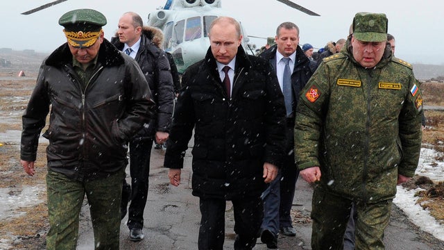 Russian President Vladimir Putin, center, and Russian military commanders walk upon arrival to watch a military exercise near St. Petersburg 