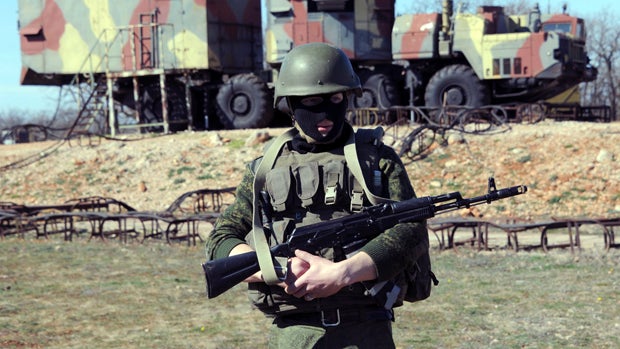 A member of the Russian forces stands guard in front of surface-to-air S300 missiles in a Ukrainian anti-aircraft missile unit on the Cape of Fiolent in Sevastopol, Ukraine, March 5, 2014. 
