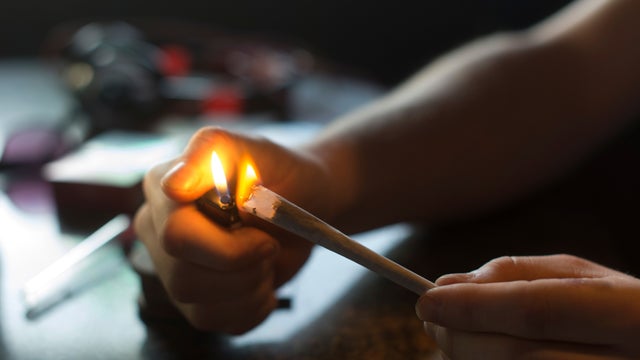 A visitor lights a marijuana joint in coffee shop Mississippi in Maastricht, southern Netherlands 
