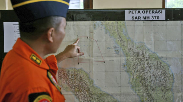 An Indonesia air force officer shows a map of Malacca Straits during a briefing prior to a search operation for the missing Malaysia Airlines Boeing 777 