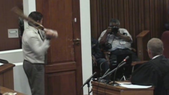 Top police forensic investigator Lt-Col Johannes Vermeulen attempts to reenact blows delivered to a bathroom door by Oscar Pistorius 