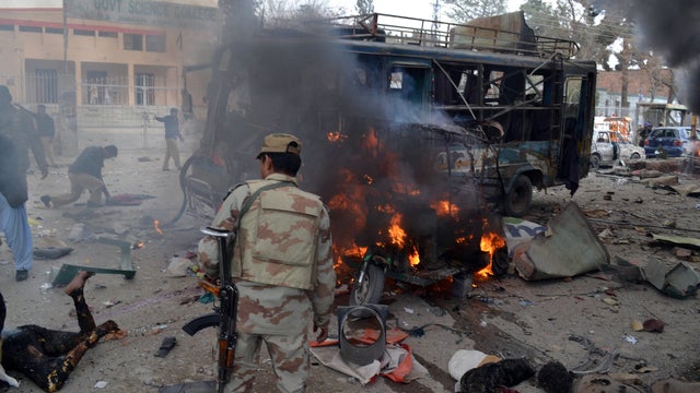 A Pakistani security officer is pictured amid bodies and wreckage at the scene of a bomb blast in Quetta 