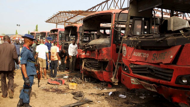 Bomb experts search for evidence in front of buses at a bomb blast scene at Nyanyan, in Abuja 
