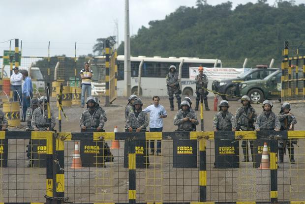 Police officers stand guard during a demonstration against Norte Energia - the company responsible for the construction of Belo Monte hydroelectric power plant - demanding compensation for the loss of income from the flooding of the Xingu river near Altamira, in the northern state of Para, Brazil 