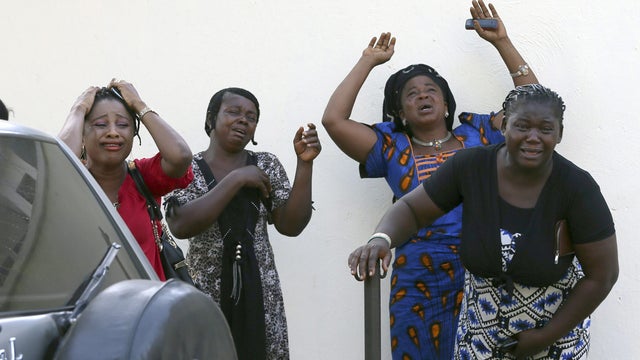 Bystanders react as victims of a bomb blast arrive at the Asokoro General Hospital in Abuja 