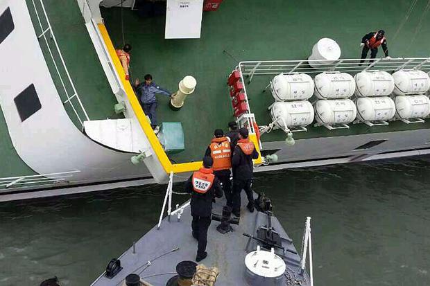 A passenger is rescued by South Korean maritime policemen from the sinking ship Sewol in the sea off Jindo April 16, 2014, in this picture provided by the Korean coast guard and released by Yonhap. 