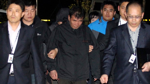 Lee Joon-seok, center, captain of the South Korean ferry Sewol, which capsized, arrives at a court in Mokpo, South Korea, April 18, 2014. 