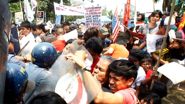 Protesters scuffle with anti-riot police during a protest against the upcoming visit of President Obama, in front of the U.S. Embassy in Manila 