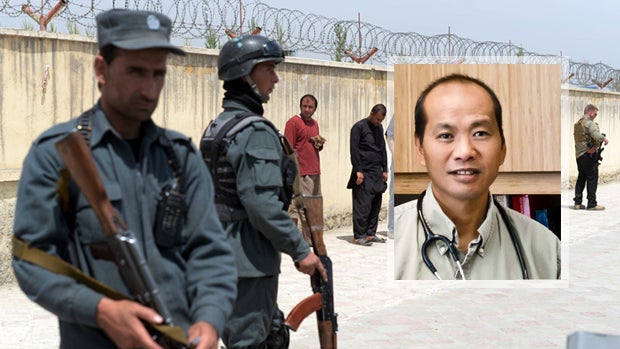 Afghan policemen keep watch as foreign nationals wait outside the Cure hospital in Kabul, Afghanistan, April 24, 2014, where a guard shot dead three Americans, including Dr. Jerry Umanos, inset. 