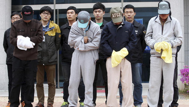 Crew members of the sunken Sewol ferry stand outside a court in Mokpo, South Korea, after investigators sought warrants of their arrest at the court April 26, 2014. 
