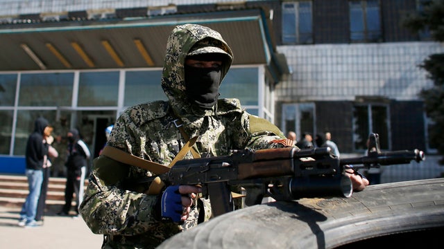 A pro-Russian armed man holds his weapon in front of the seized town administration building in Kostyantynivka 