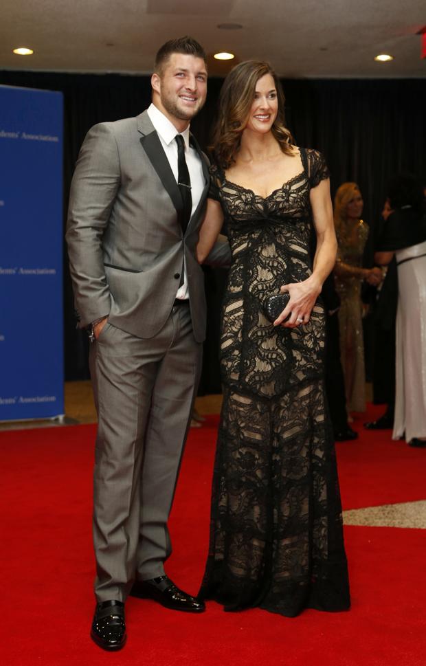 Football player Tim Tebow and guest arrive on the red carpet at the annual White House Correspondents' Association dinner in Washington May 3, 2014. 