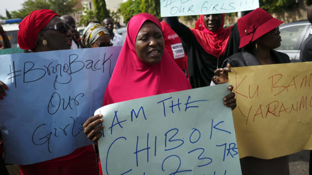 Activist Aisha Yesufu, center, 40, shouts slogans as she holds placards with fellow protesters in Abuja, Nigeria, May 13, 2014. 